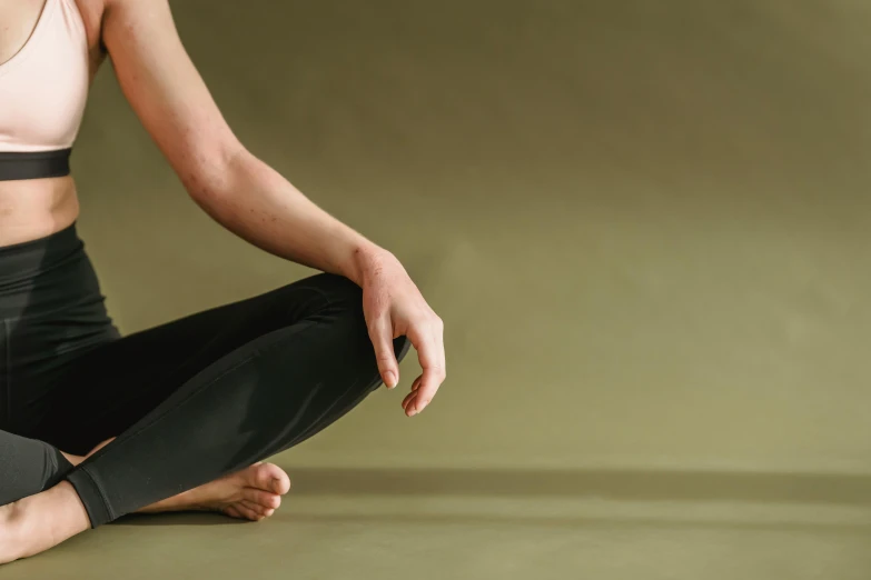 a woman sitting in the middle of a yoga pose, by Rachel Reckitt, hand model, background image, muted green, manuka