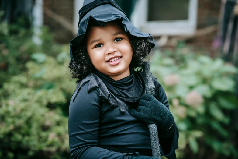 a little girl dressed up in a witch costume, a photo, unsplash, hurufiyya, jayson tatum as guerilla heroica, thumbnail, portrait of fin wildcloak, black