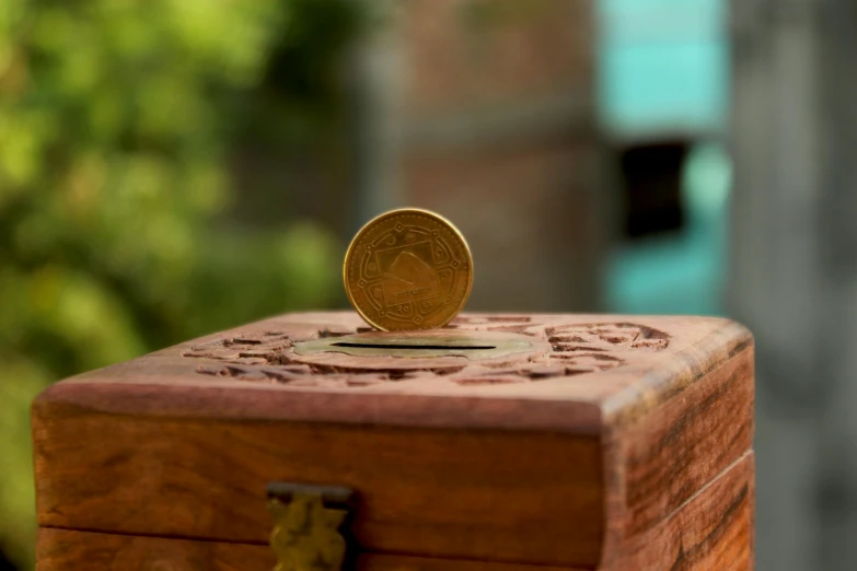 a coin sitting on top of a wooden box, by Jessie Algie, pexels contest winner, uttarakhand, sundial, macro photography 8k, small stature