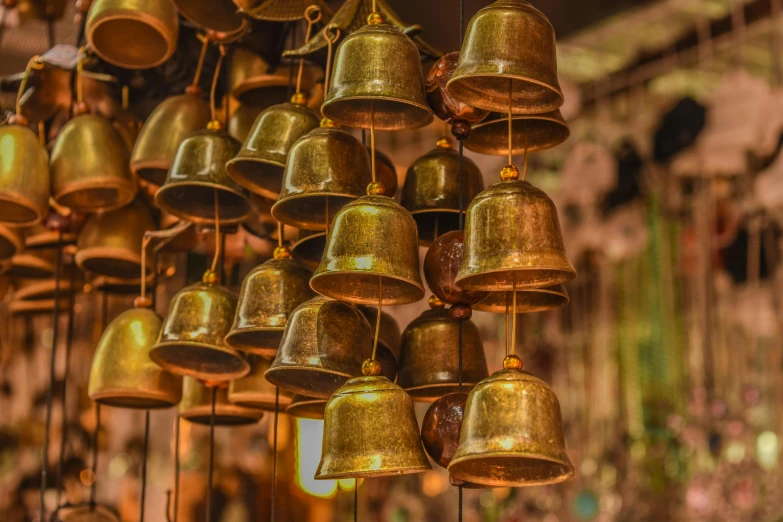 a bunch of bells hanging from a ceiling, shades of gold display naturally, temples, ad image, brown