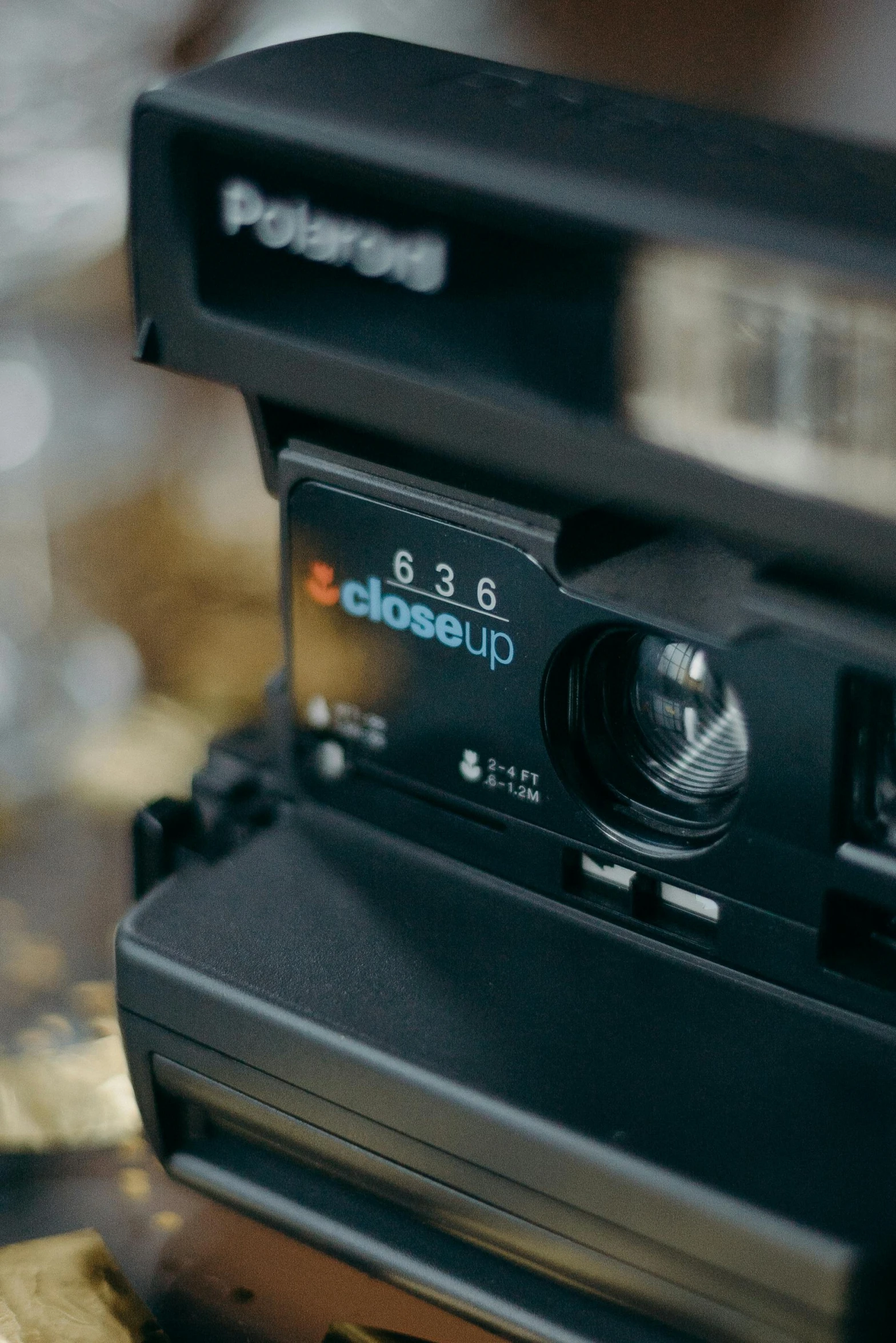 a polaroid camera sitting on top of a table, by Robbie Trevino, unsplash, holography, face cluse - up, super close up, cinematic panavision 5384 film, bottom body close up