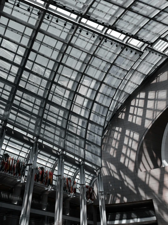 a clock hanging from the ceiling of a building, inspired by János Nagy Balogh, unsplash contest winner, light and space, steel archways, huge greenhouse, great light and shadows”, promo image