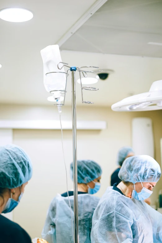 a group of people that are standing in a room, surgical equipment