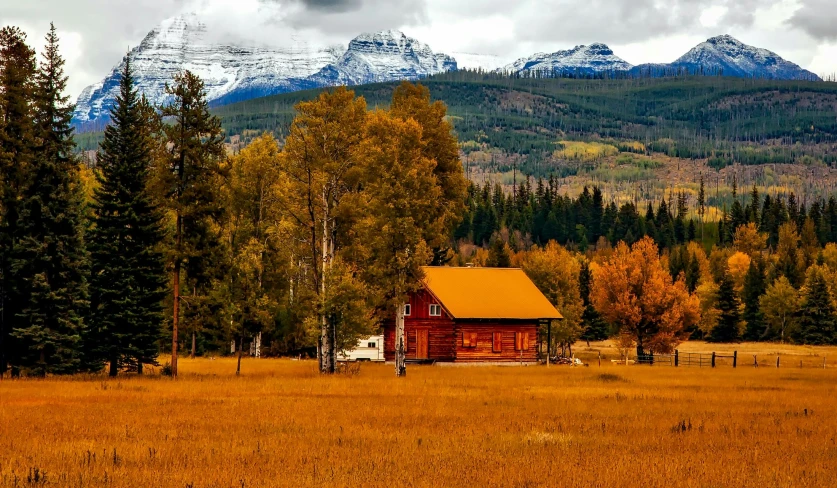 a cabin in a field with mountains in the background, by Jim Nelson, pexels contest winner, golden colors, house in forest, red building, white