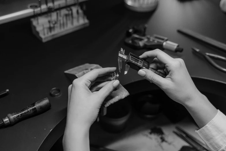 a black and white photo of a person cutting a piece of metal, by Emma Andijewska, professional gunsmithing, inspect in inventory image, miniature product photo, ✨🕌🌙