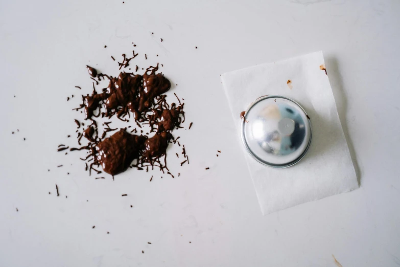 a piece of chocolate sitting on top of a napkin, a still life, unsplash, glossy sphere, sprinkles, stainless steel, poop