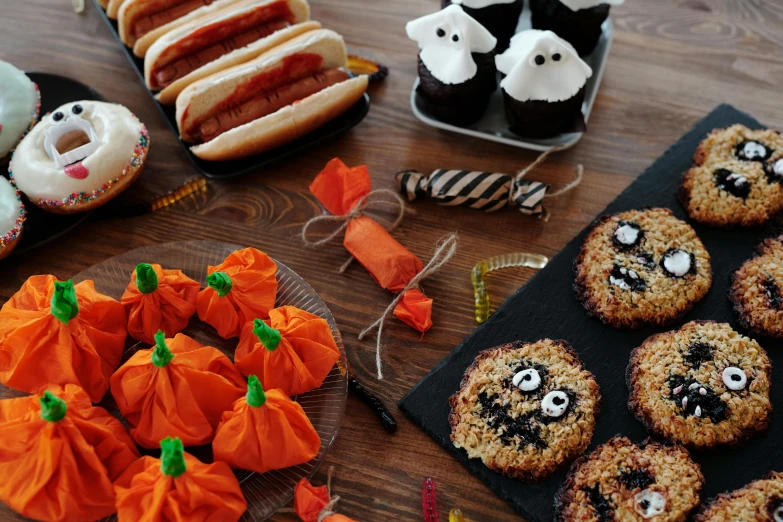 a table topped with lots of food on top of a wooden table, trick or treat, listing image, units, orange and black