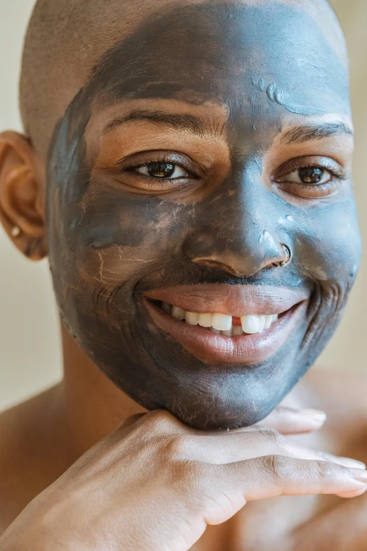 a close up of a person with a face mask, looking happy, charcoal color skin, androgynous face, pleasing face