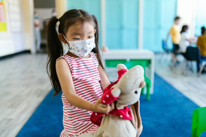 a little girl wearing a face mask holding a teddy bear, school, jia ruan, softplay, 1x