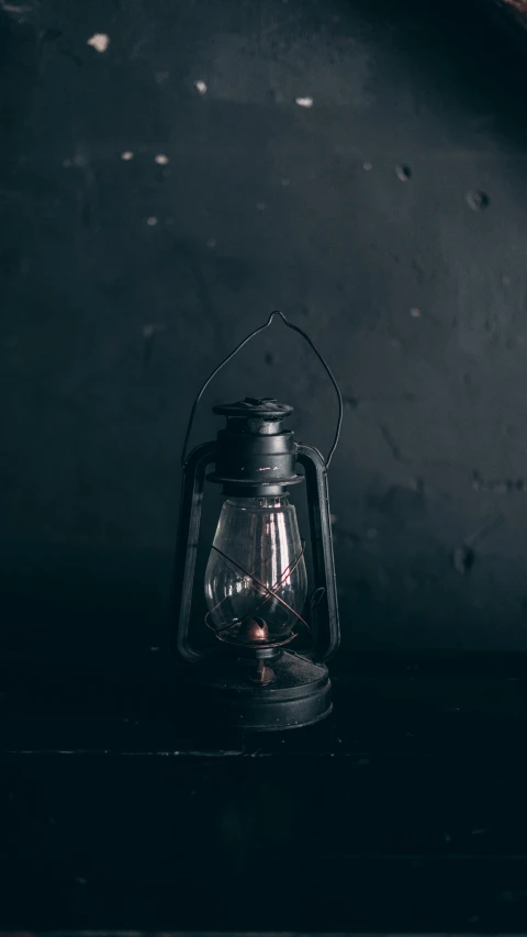 a black lantern sitting on top of a table, trending on pexels, conceptual art, retro dark vintage, instagram photo, studio photo, rusty