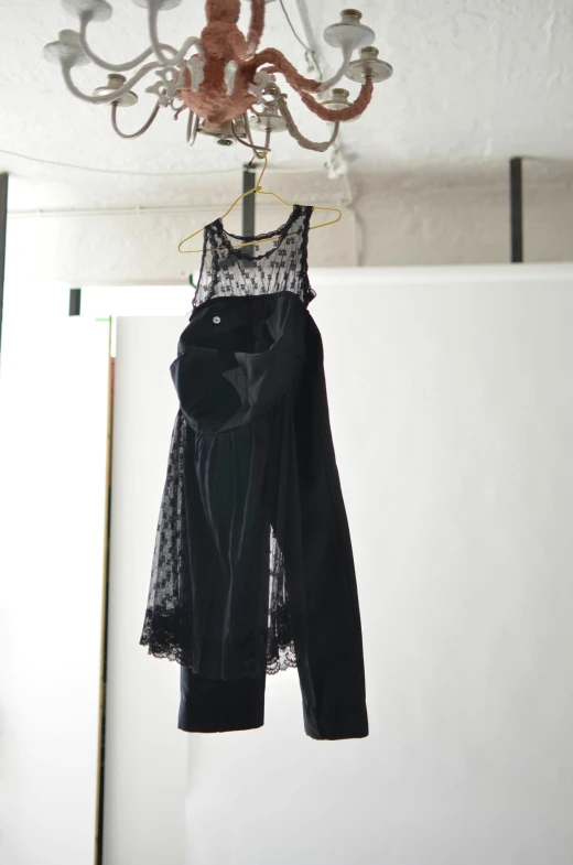 a dress hanging from a chandelier in a room, by Ellen Gallagher, black tanktop, nizou yamamoto, main colour - black, velvet with lace gown