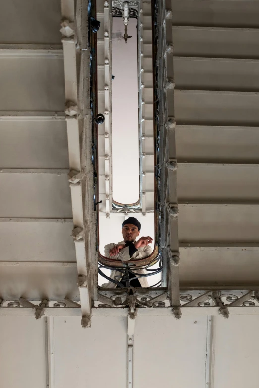 a man taking a picture of himself in a mirror, inspired by Leandro Erlich, unsplash, art nouveau, look down a cellar staircase, white mechanical details, lookout tower, high angle