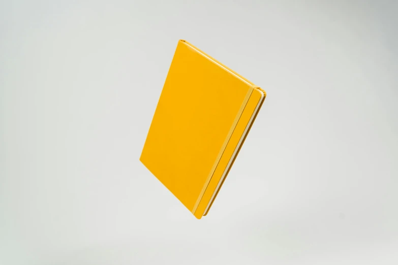 a yellow book floating in the air, by Jan Rustem, bauhaus, orange: 0.5, silicone cover, solid color, shiny golden