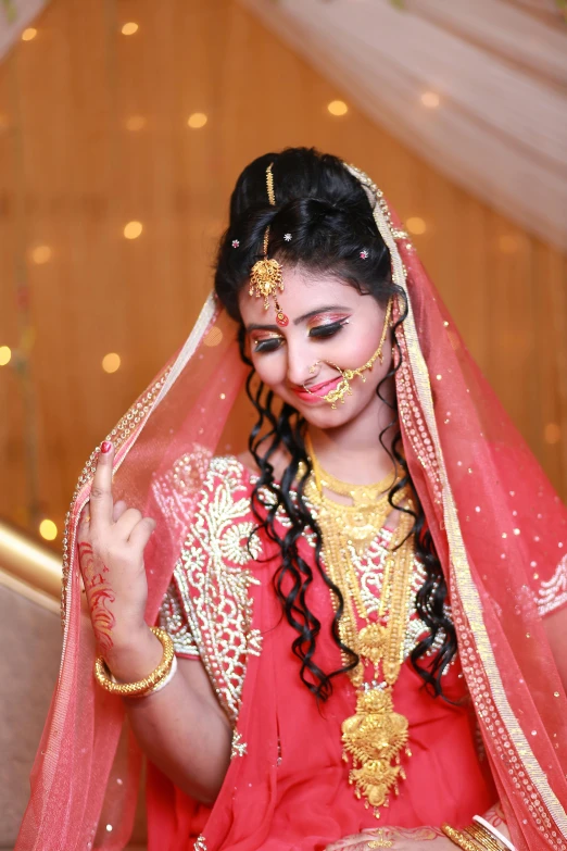 a woman in a red dress and gold jewelry, inspired by Saurabh Jethani, hurufiyya, long braided hair on top of head, bangladesh, wearing a wedding dress, having fun. vibrant