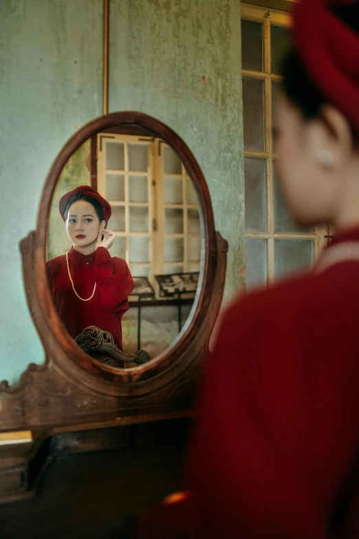 a woman looking at her reflection in a mirror, inspired by Steve McCurry, wearing a red captain's uniform, vietnamese woman, vintage aesthetic, history drama