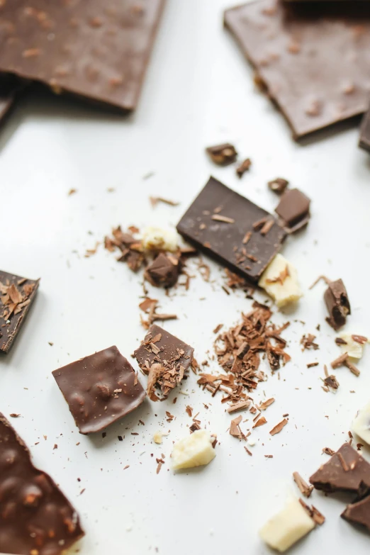 a white plate topped with pieces of chocolate, by Jessie Algie, unsplash, ilustration, square, brunettes, crushed