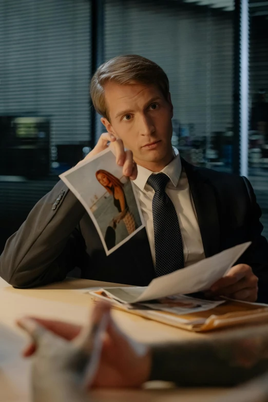 a man sitting at a table talking on a cell phone, a stock photo, trending on reddit, photorealism, better call saul, caspar david, in his suit, epic romance