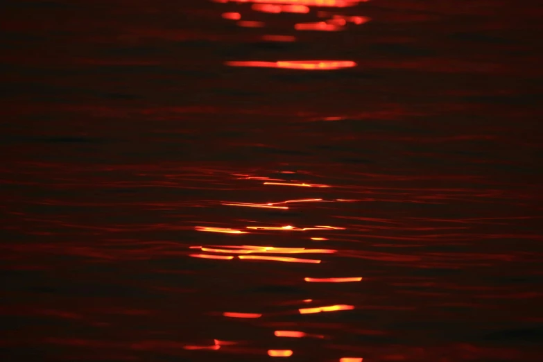 the sun is setting over a body of water, inspired by Elsa Bleda, detailed red lighting, close-up photograph, metallic red, red neon