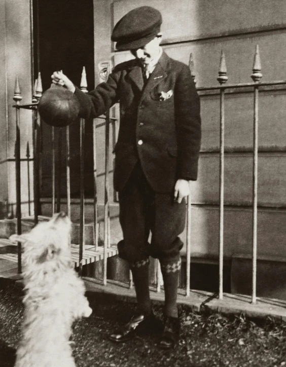 a black and white photo of a man and a dog, by August Sander, surrealism, holding a ball, in uniform, louis william wain, archival quality image