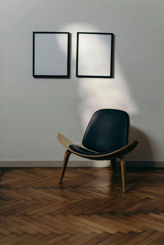 a black chair sitting on top of a hard wood floor, inspired by Constantin Hansen, unsplash contest winner, visual art, clamp shell lighting, framed in image, catalog photo, displayed in a museum