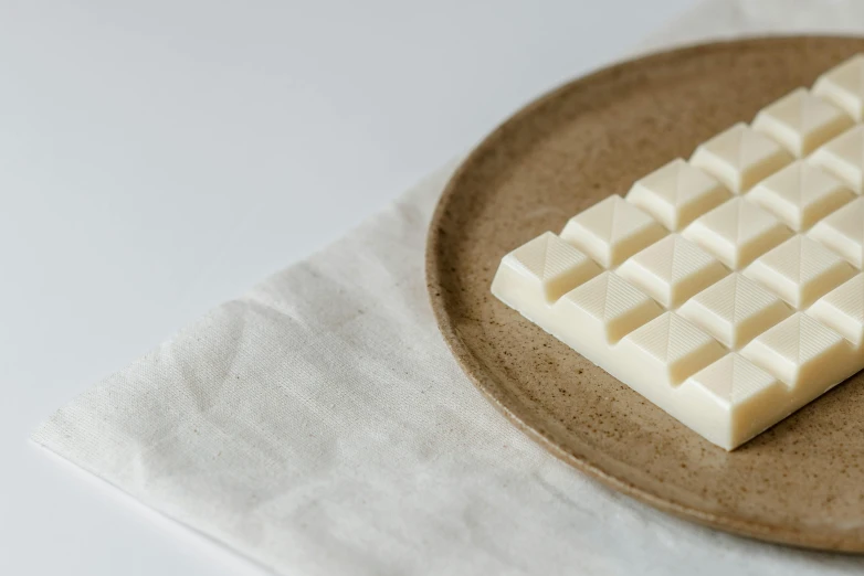 a white keyboard sitting on top of a brown plate, milk cubes, ecru cloth, fully chocolate, koji morimoto