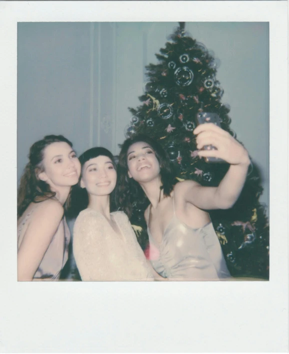 three women taking a picture of a christmas tree, a polaroid photo, by Grace Clements, kiko mizuhara, digital image, blank, angela sarafyan