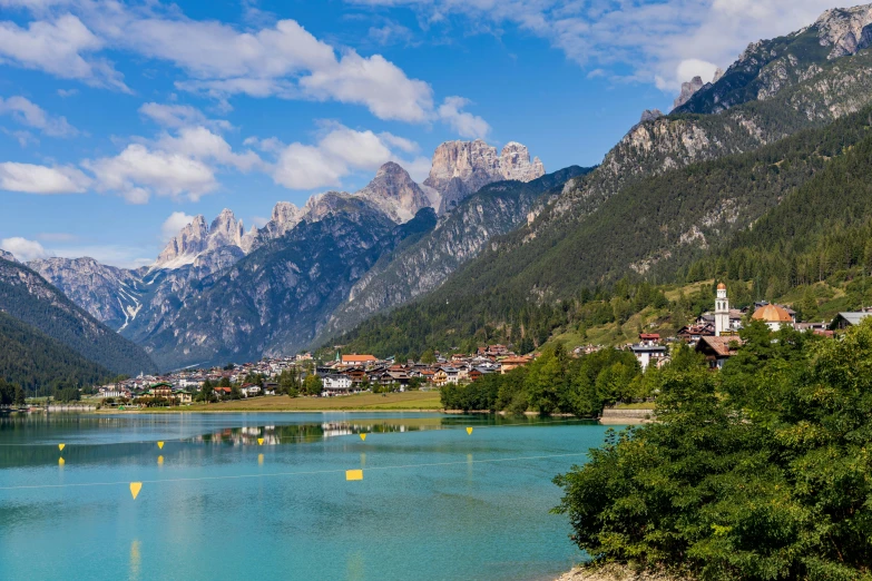 a body of water with mountains in the background, by Carlo Martini, pexels contest winner, renaissance, beautiful small town, majestic spires, thumbnail, green waters