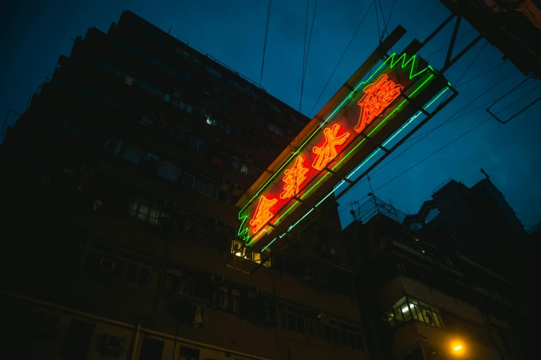 a neon sign hanging from the side of a building, by Patrick Ching, pexels contest winner, shan shui, viewed from a distance, jim cheung, under street lamp