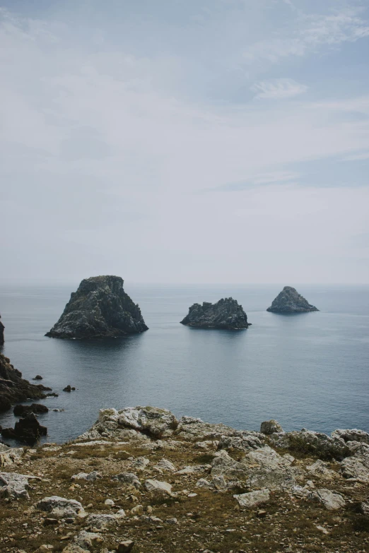 a group of rocks in the middle of a body of water, piroca, asymmetrical spires, medium format, two medium sized islands