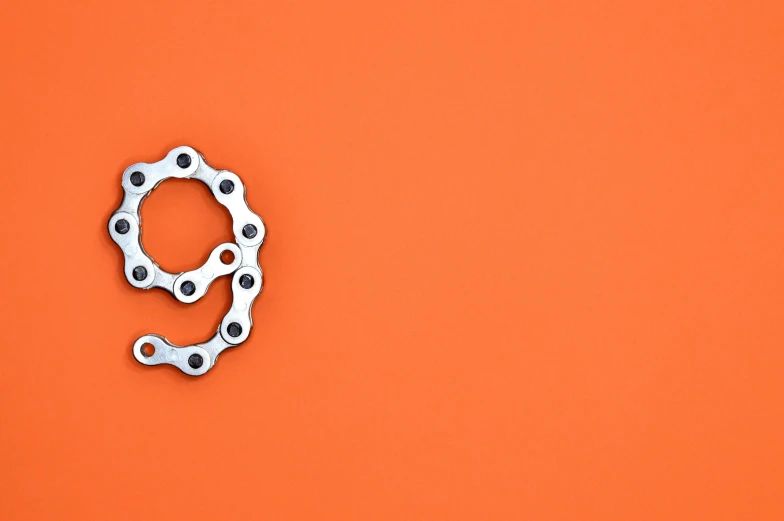 a bicycle chain on an orange background, trending on pexels, dividing it into nine quarters, sierpinski gasket, negative space, hook as ring