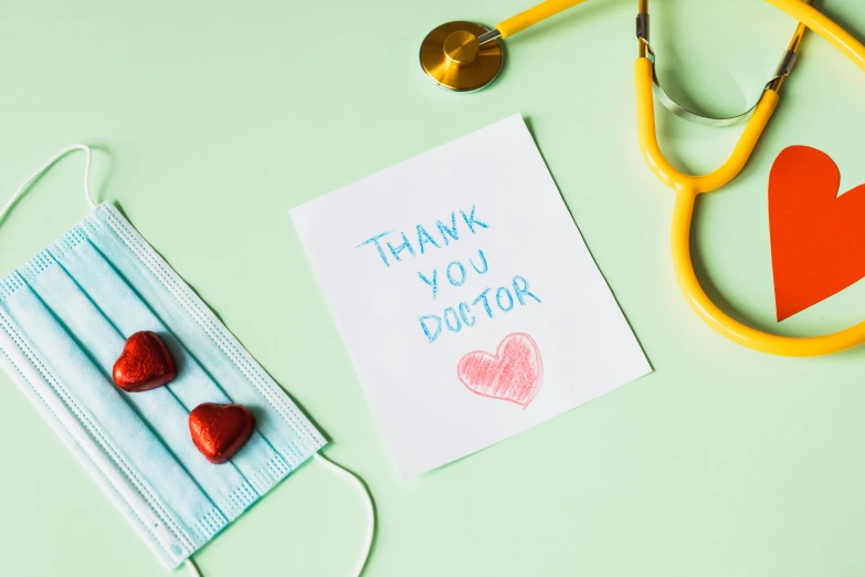 a thank you doctor card next to a stethoscope and a stethoscope, by Julia Pishtar, pexels contest winner, greeting card, three - quarter view, schools, where a large