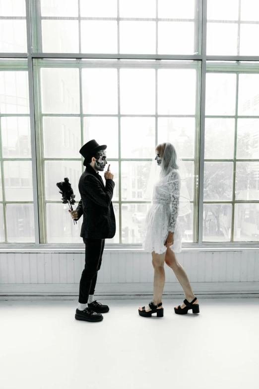 a couple of people that are standing in front of a window, unsplash, international gothic, wearing a bone gas mask, wedding, white room, ( ( theatrical ) )