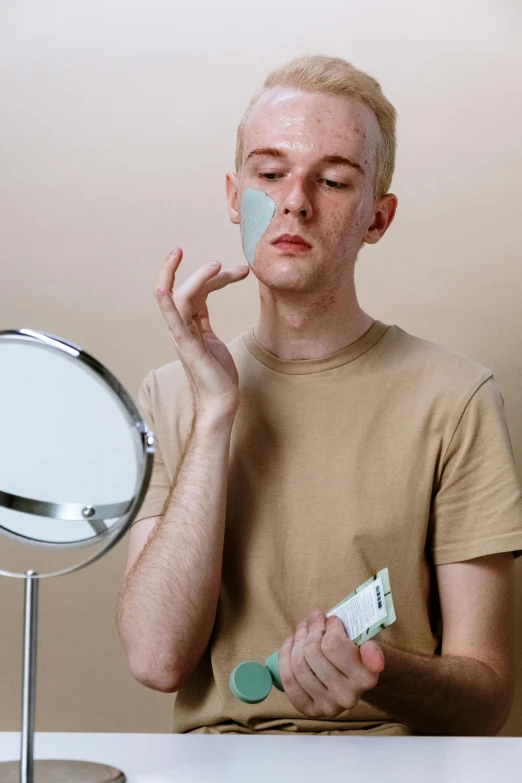 a man shaving his face in front of a mirror, an album cover, pexels contest winner, green facemask, non binary model, pale smooth, skincare