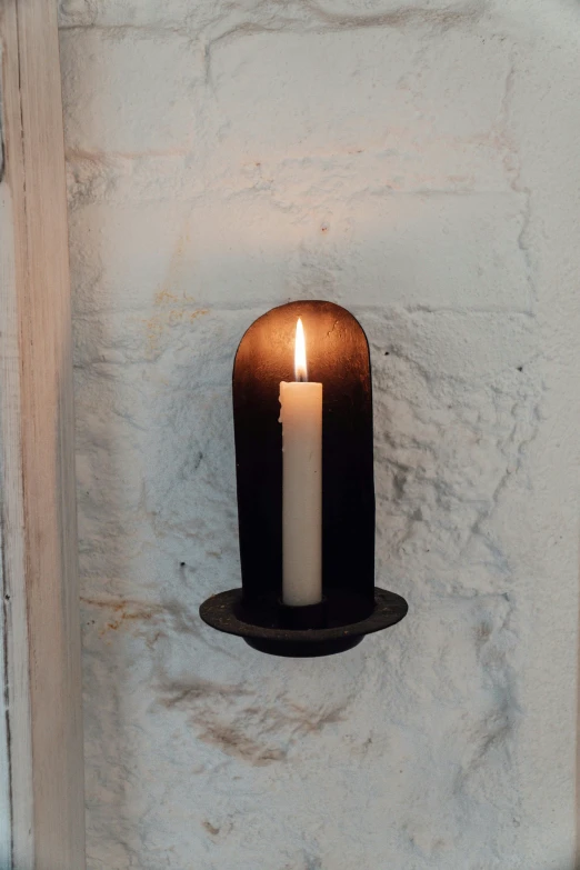 a candle that is sitting on a wall, by Nina Hamnett, folk art, clamp shell lighting, medium lighting, cottage decor, umbra