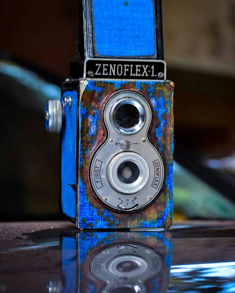 an old camera sitting on top of a table, by Joe Stefanelli, pexels contest winner, art photography, blue translucent resin, hand painted textures on model, texturing xyz, album cover