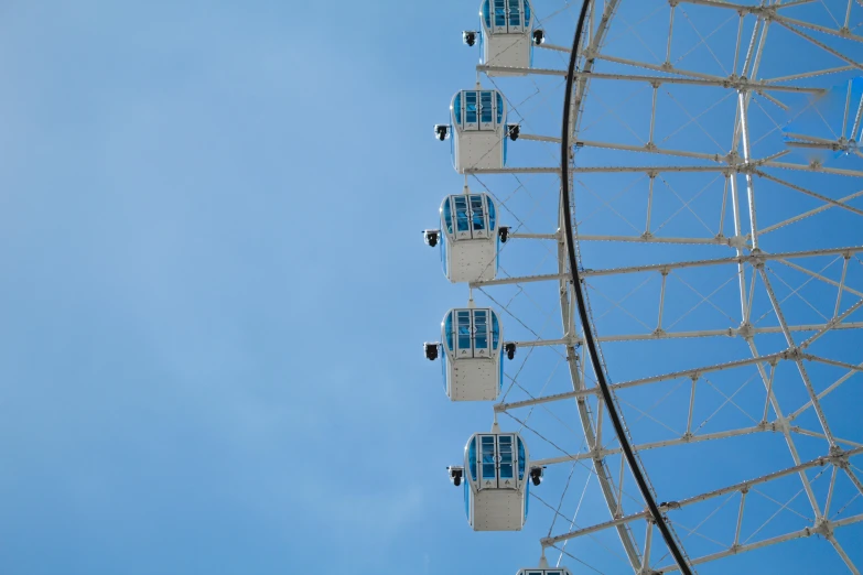 a ferris wheel in front of a blue sky, by Julia Pishtar, pexels contest winner, romanticism, aquamarine windows, white and blue, high - angle, london south bank