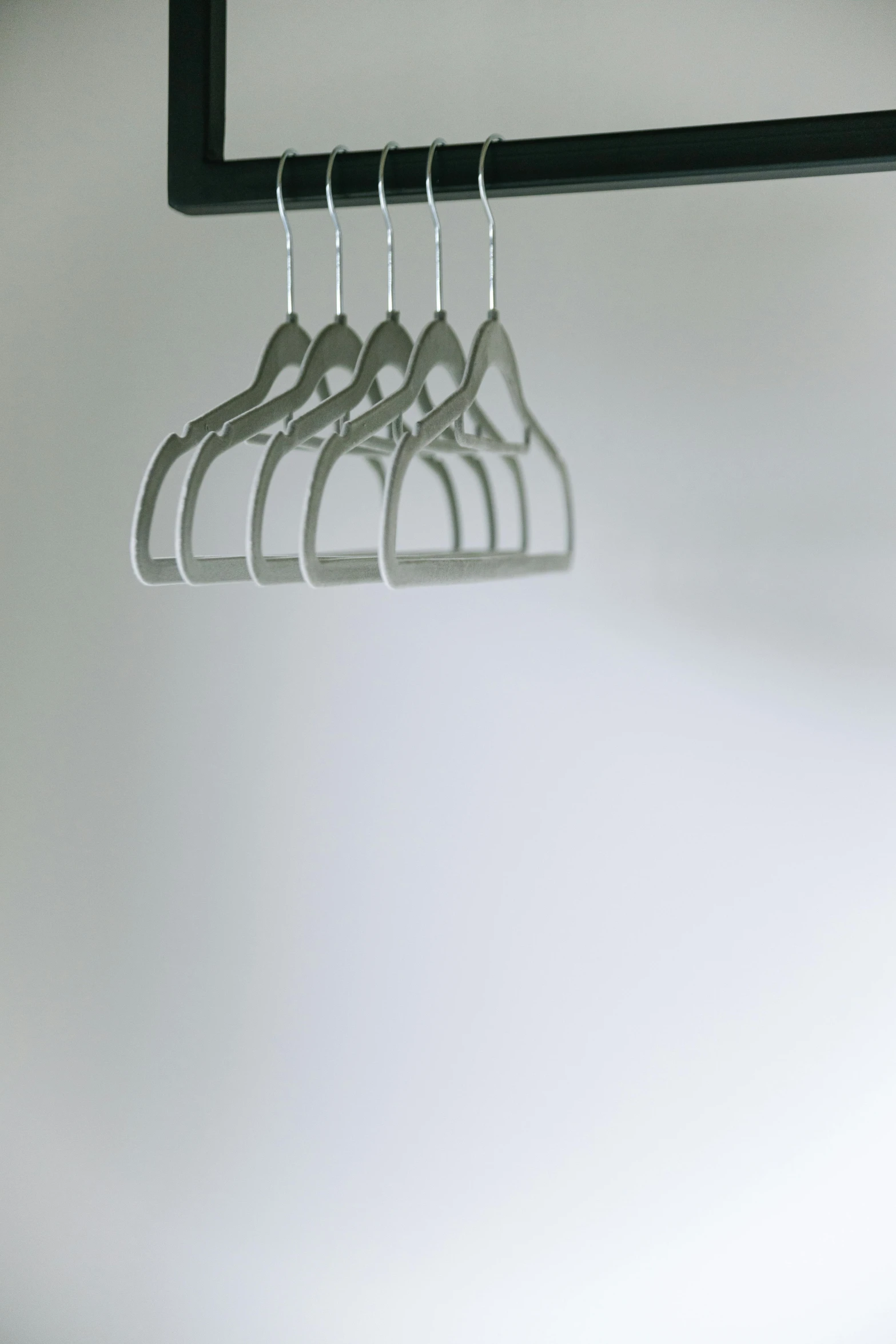 a close up of a hanger with clothes on it, by Peter Alexander Hay, minimalism, soft volumetric lighting, silver，ivory, healthcare, solid grey