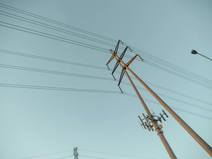 a couple of power poles sitting next to each other, unsplash, hyperrealism, clear blue sky vintage style, instagram post, glowing - thin - wires, stacked image