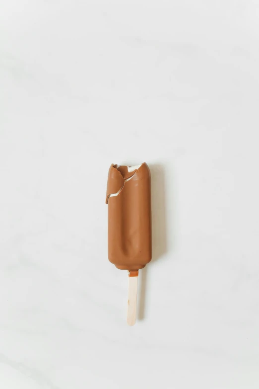 a close up of an ice cream on a stick, raw sienna, flat lay, detailed product image, caramel. rugged