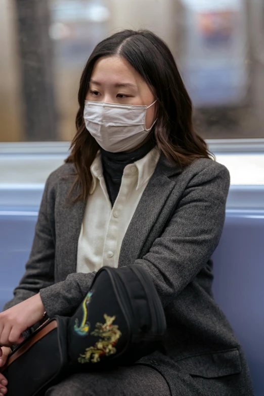 a woman sitting on a train wearing a face mask, happening, wearing jacket, walking, mei-ling zhou, grey