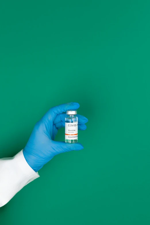 a person in blue gloves holding a bottle of medicine, coronarender, thumbnail, synthetic, colour corrected