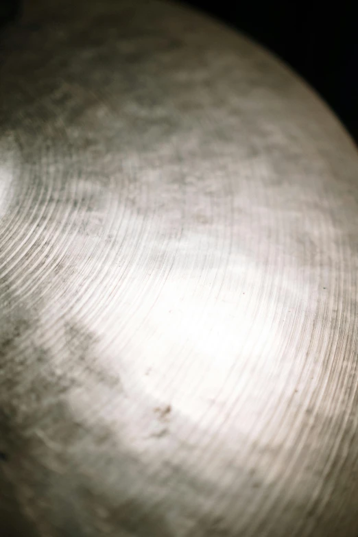 a close up of a cyb on a black background, an album cover, by Doug Ohlson, unsplash, lots of cymbals, soft surface texture, silver，ivory, dapped light