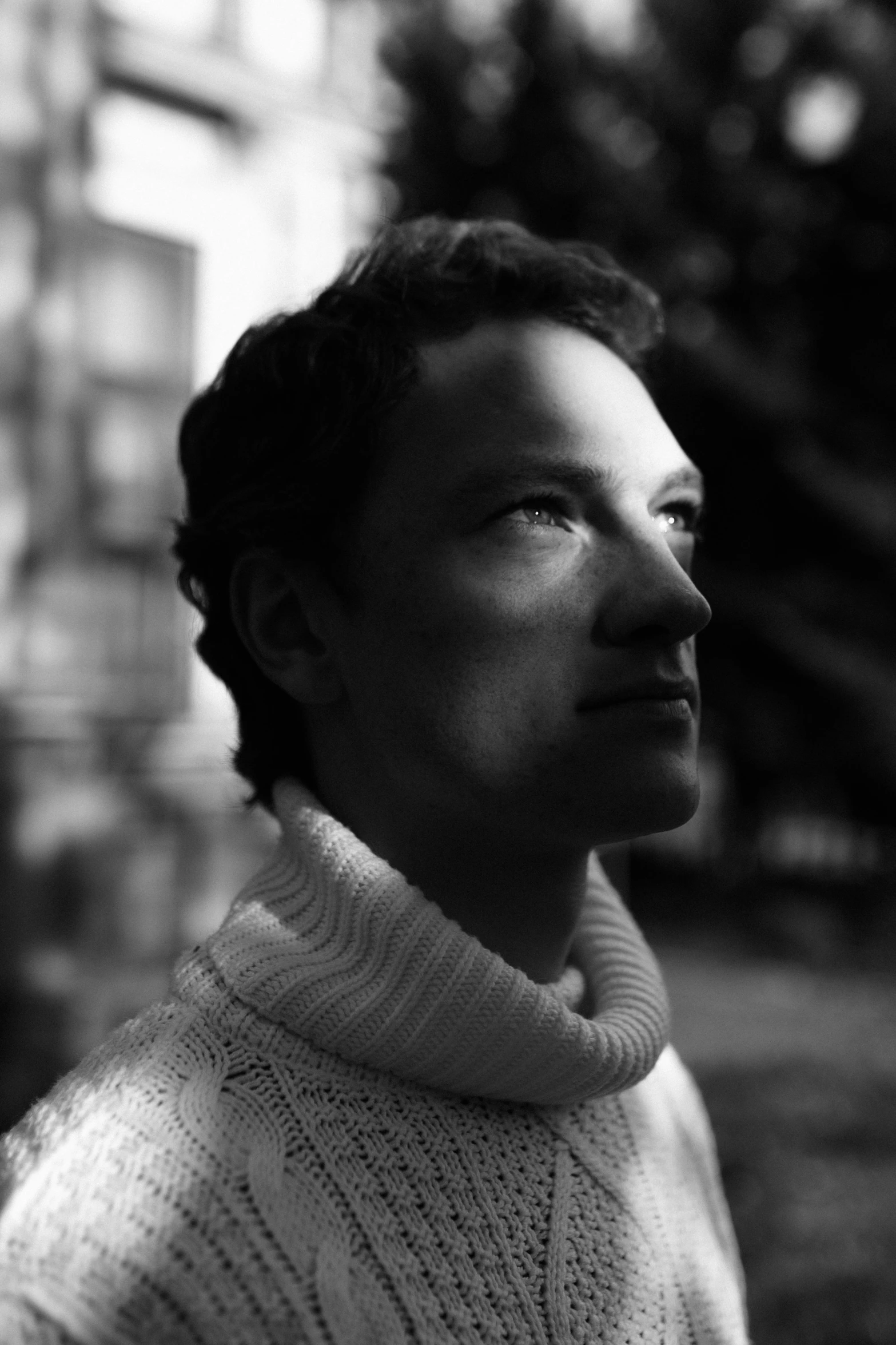 a black and white photo of a man in a sweater, inspired by Andrei Ryabushkin, tumblr, christian horner portrait, slightly sunny, backlit portrait, dressed in a frilly ((ragged))