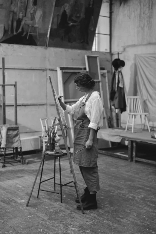 a black and white photo of a woman painting, set design, wearing overalls, square, impressionist artists