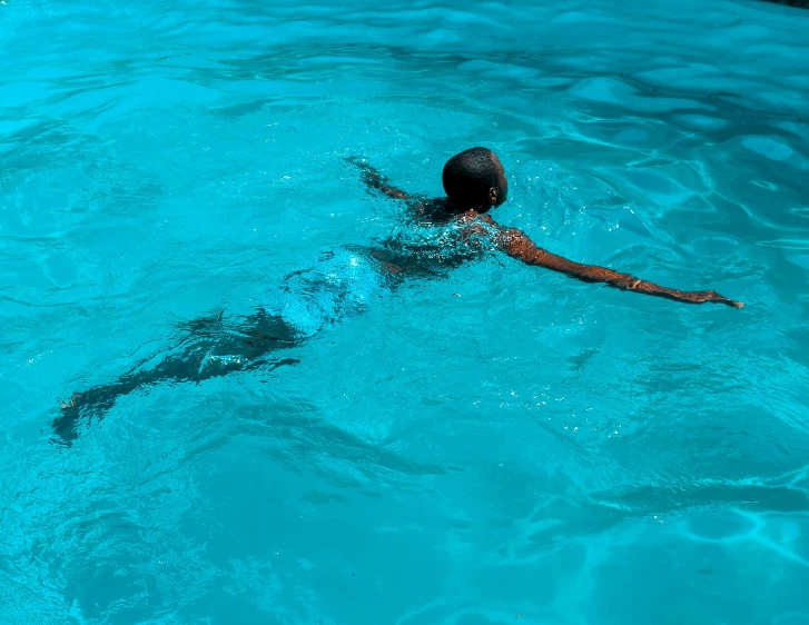 a person swimming in a pool with a frisbee, by Maggie Hamilton, pexels contest winner, hurufiyya, dark-skinned, light blue water, slim aarons, no words 4 k