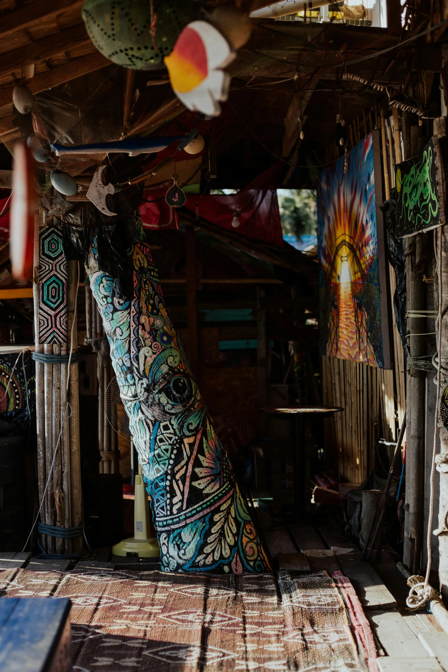 a room with a tree in the middle of it, by Jessie Algie, unsplash, maximalism, in a tiki bar, long trunk holding a wand, batik, shack close up