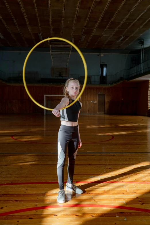 a young girl holding a hula hoop in a gym, a portrait, by Matthias Stom, pexels contest winner, arabesque, mandy jurgens golden ratio, square, anna nikonova aka newmilky, high school