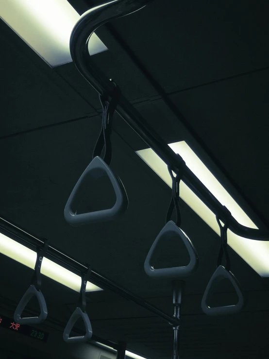 a bunch of bags hanging from the ceiling of a bus, by Attila Meszlenyi, ring lighting, dark academia aesthetic, metal handles, sports photo