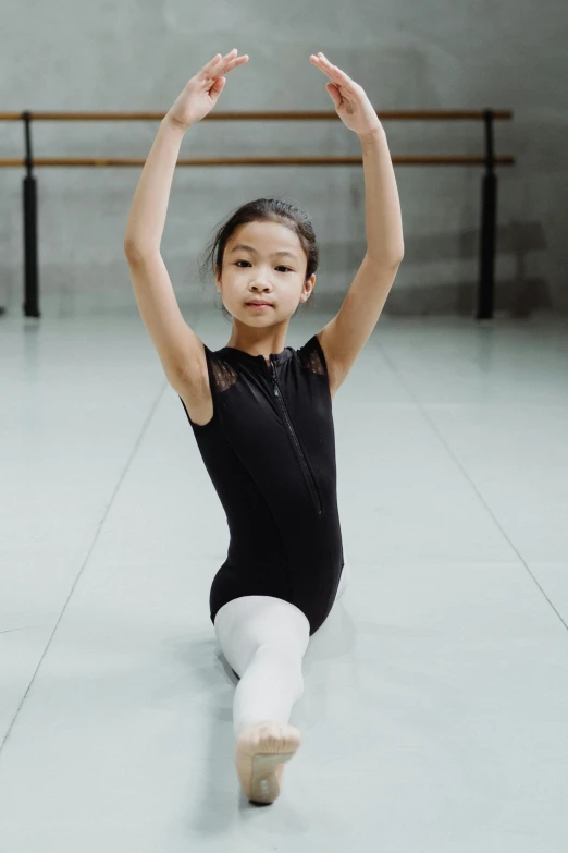 a little girl in a black leo leo leo leo leo leo leo leo leo leo leo leo, inspired by Fei Danxu, unsplash, arabesque, wearing leotard, taiwan, photographed for reuters, innovation