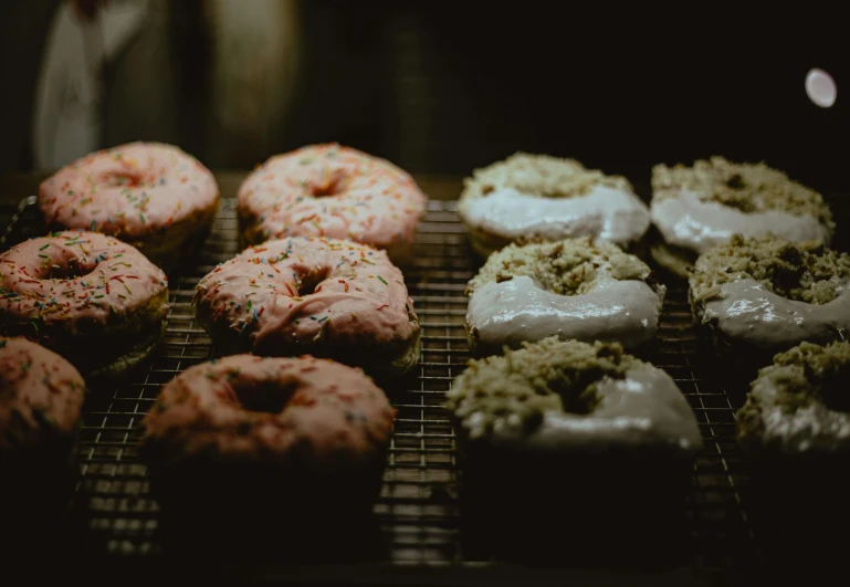 a bunch of doughnuts that are on a rack, by Emma Andijewska, trending on unsplash, dimly lit, grain”, 15081959 21121991 01012000 4k, varying ethnicities